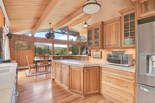 kitchen featuring pendant lighting, lofted ceiling with beams, stainless steel fridge, ceiling fan, and light hardwood / wood-style floors