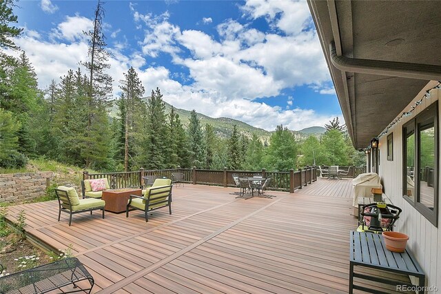 wooden deck featuring an outdoor hangout area and a mountain view