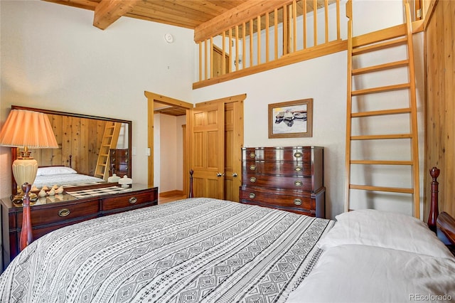 bedroom featuring beam ceiling, a high ceiling, and wooden ceiling