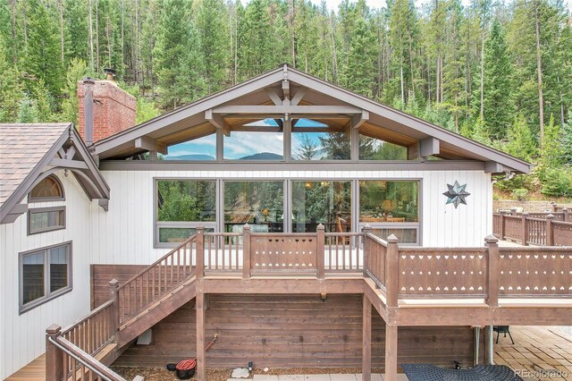 1774 Upper Bear Creek Rd, Evergreen, CO 80439 - back of property with a forest view, stairway, and a wooden deck