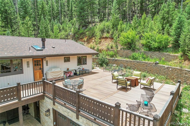 1774 Upper Bear Creek Rd, Evergreen, CO 80439 - wooden deck with a view of trees and an outdoor hangout area