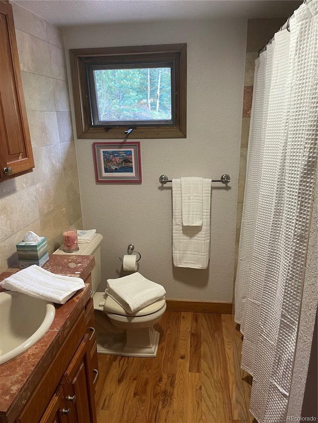 1774 Upper Bear Creek Rd, Evergreen, CO 80439 - bathroom with wood finished floors, vanity, toilet, and curtained shower
