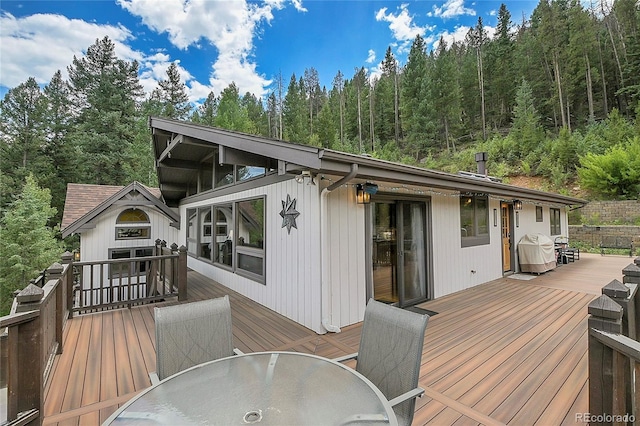 1774 Upper Bear Creek Rd, Evergreen, CO 80439 - wooden terrace with outdoor dining space, grilling area, and a wooded view