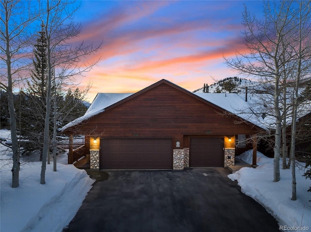 chalet / cabin featuring driveway and stone siding