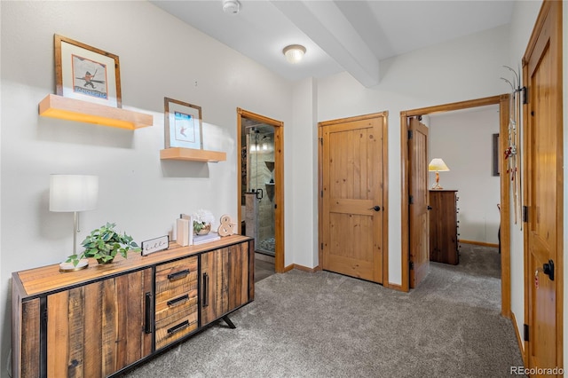 interior space with beam ceiling, light carpet, and baseboards