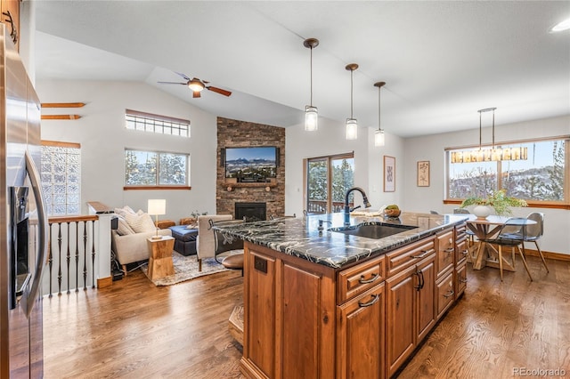 kitchen featuring plenty of natural light, a fireplace, dark wood-style flooring, and a sink