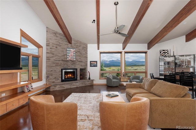 living room with beamed ceiling, a mountain view, a wealth of natural light, and a fireplace