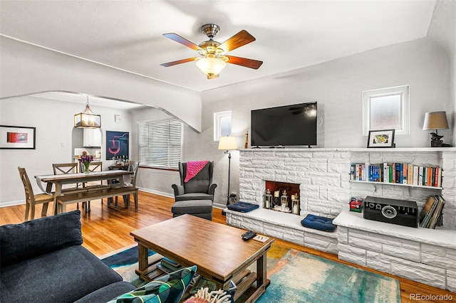 706 S Lincoln St, Denver, CO 80209 - living room featuring arched walkways, a ceiling fan, wood finished floors, and plenty of natural light
