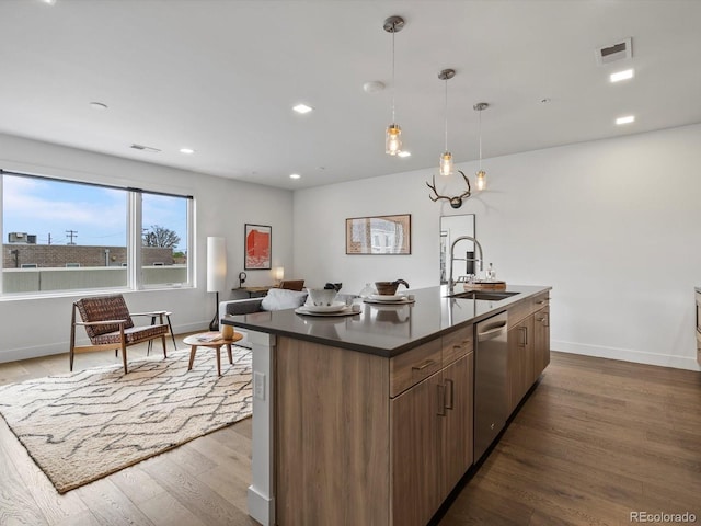 kitchen featuring dark countertops, a sink, dishwasher, dark wood finished floors, and visible vents