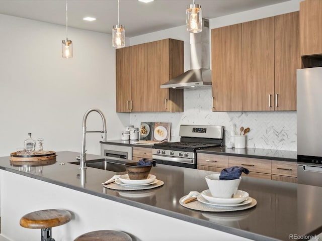 kitchen with appliances with stainless steel finishes, hanging light fixtures, dark countertops, and a breakfast bar