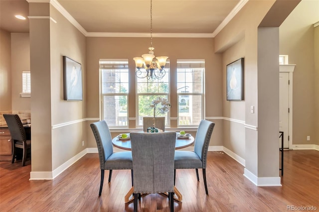 dining room with a chandelier, hardwood / wood-style flooring, and ornamental molding