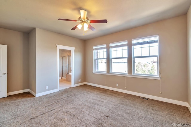 unfurnished bedroom with connected bathroom, ceiling fan, and light colored carpet