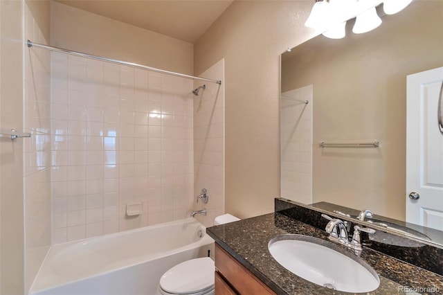 full bathroom featuring vanity, tiled shower / bath combo, and toilet