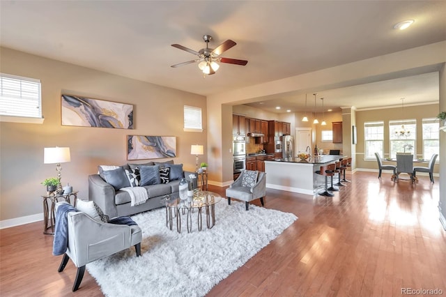 8537 E 35th Ave, Denver, CO 80238 - living area featuring wood finished floors, a ceiling fan, and a chandelier