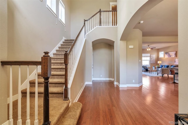 8537 E 35th Ave, Denver, CO 80238 - foyer featuring arched walkways, wood finished floors, a ceiling fan, a towering ceiling, and stairs
