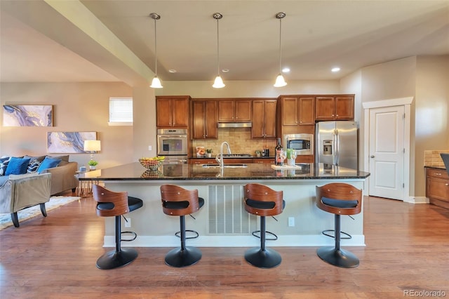 8537 E 35th Ave, Denver, CO 80238 - kitchen with stainless steel appliances, brown cabinets, dark wood-type flooring, under cabinet range hood, and recessed lighting