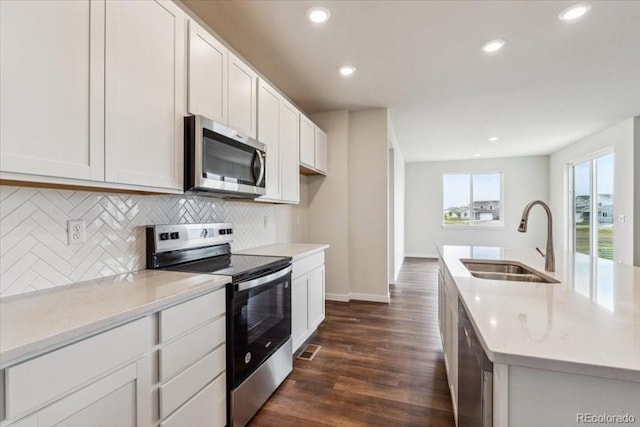 14406 Ranch St, Mead, CO 80504 - kitchen featuring appliances with stainless steel finishes, tasteful backsplash, dark wood-style floors, recessed lighting, and white cabinets