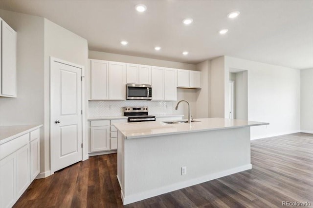 14406 Ranch St, Mead, CO 80504 - kitchen with appliances with stainless steel finishes, backsplash, dark wood-type flooring, white cabinetry, and recessed lighting