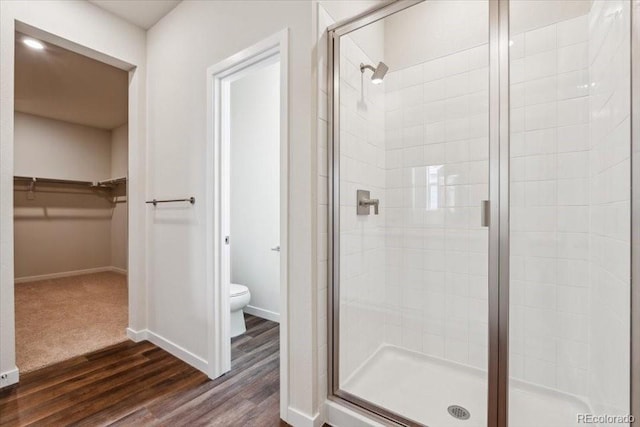 14406 Ranch St, Mead, CO 80504 - bathroom featuring a stall shower, a spacious closet, and wood finished floors