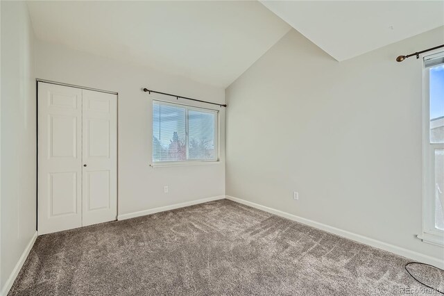 unfurnished bedroom with carpet, lofted ceiling, and a closet