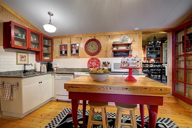 80 Meadow Ln, Bailey, CO 80421 - kitchen with white appliances, light wood-style flooring, glass insert cabinets, hanging light fixtures, and wooden walls