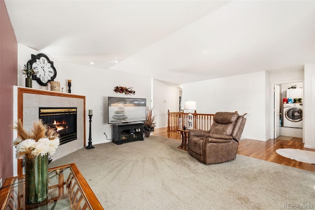 carpeted living room featuring washer / dryer and a fireplace