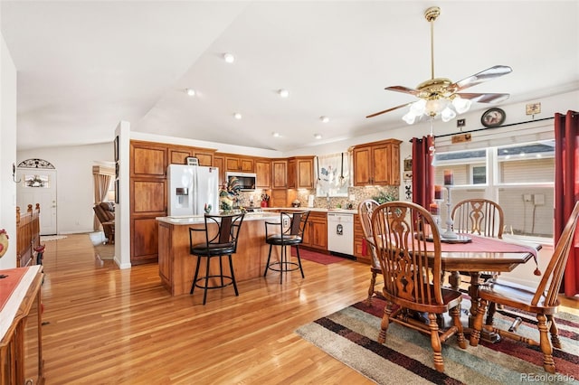 dining room featuring ceiling fan, lofted ceiling, and light hardwood / wood-style floors