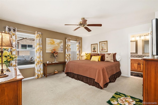 carpeted bedroom with connected bathroom and ceiling fan