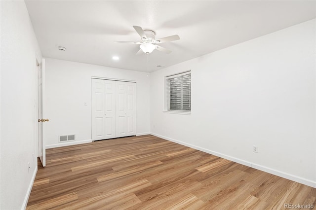 unfurnished bedroom with a closet, ceiling fan, and light wood-type flooring