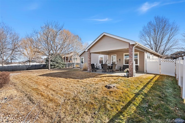 rear view of house featuring a patio area and a lawn