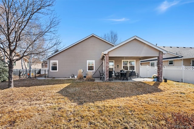 rear view of property featuring a patio area and a lawn