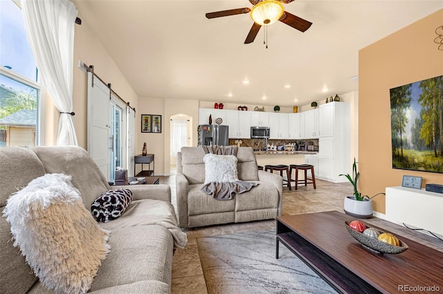 8004 Brittinger Way, Colorado Springs, CO 80951 - living room with arched walkways, a ceiling fan, and a barn door