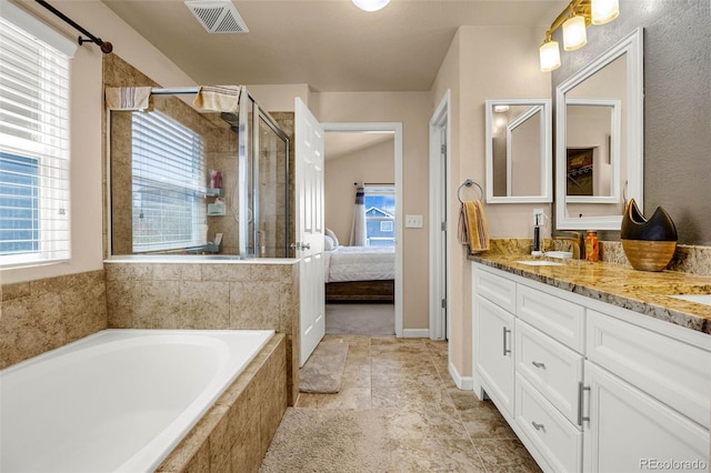 8004 Brittinger Way, Colorado Springs, CO 80951 - ensuite bathroom featuring double vanity, a bath, a stall shower, and plenty of natural light