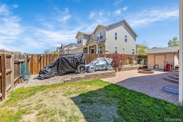 8004 Brittinger Way, Colorado Springs, CO 80951 - back of property featuring a fenced backyard, an outdoor structure, a patio, and board and batten siding