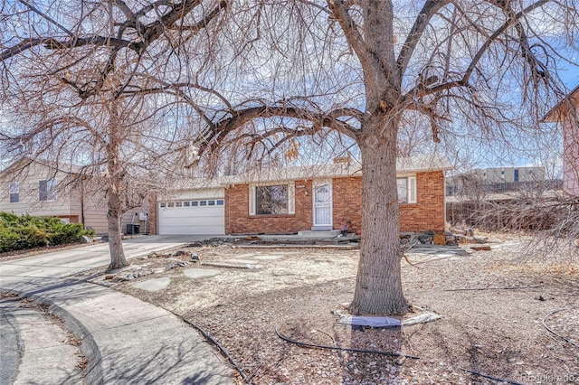 view of front of home featuring a garage, brick siding, and driveway