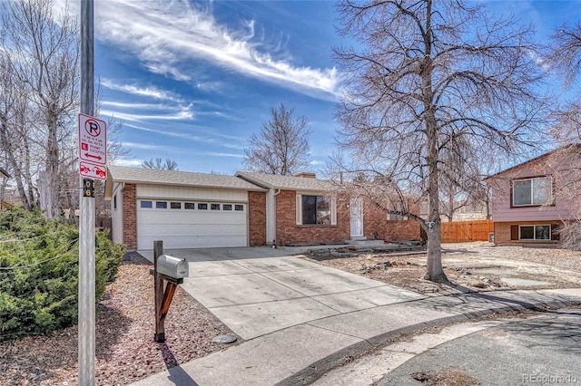 view of front facade featuring a garage, driveway, fence, and brick siding