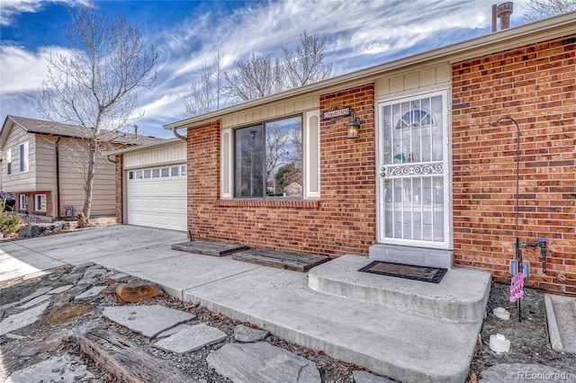 exterior space with driveway, brick siding, and an attached garage