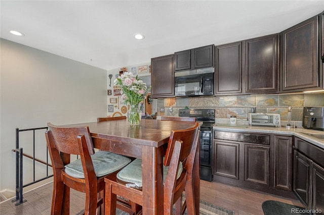 kitchen featuring tasteful backsplash, black appliances, and wood finished floors