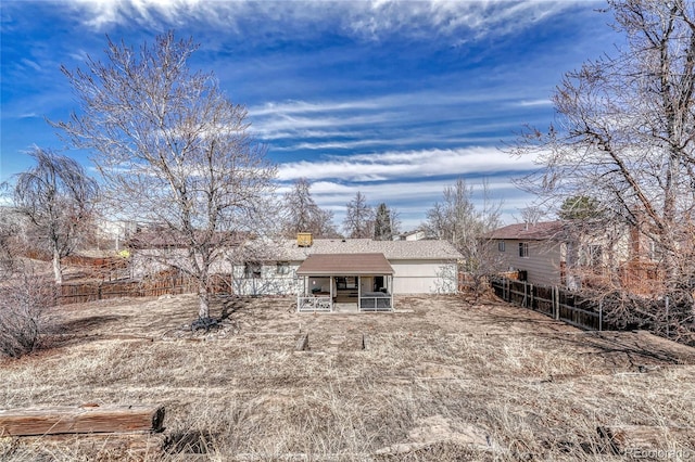 rear view of house featuring a shingled roof, a chimney, and fence