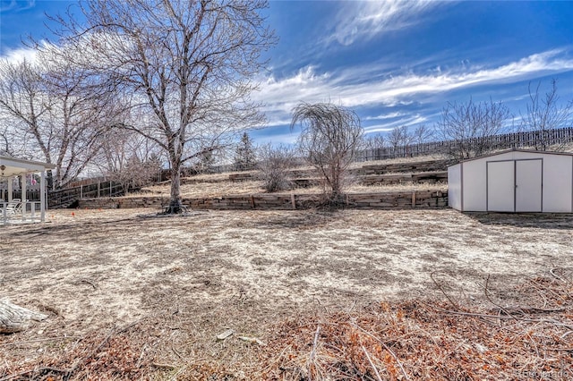 view of yard featuring a storage shed, an outdoor structure, and fence