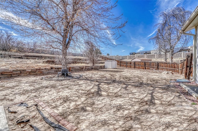 view of yard with a storage shed, an outdoor structure, and a fenced backyard