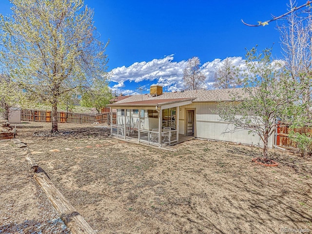 back of property featuring a patio area, a fenced backyard, and a chimney