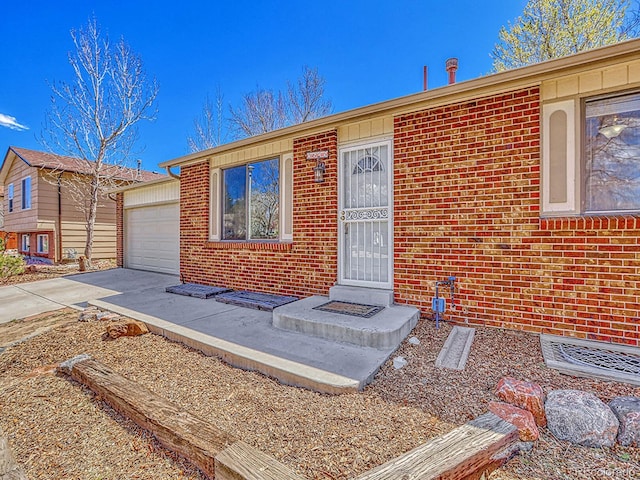 view of front of house with brick siding, a garage, and concrete driveway