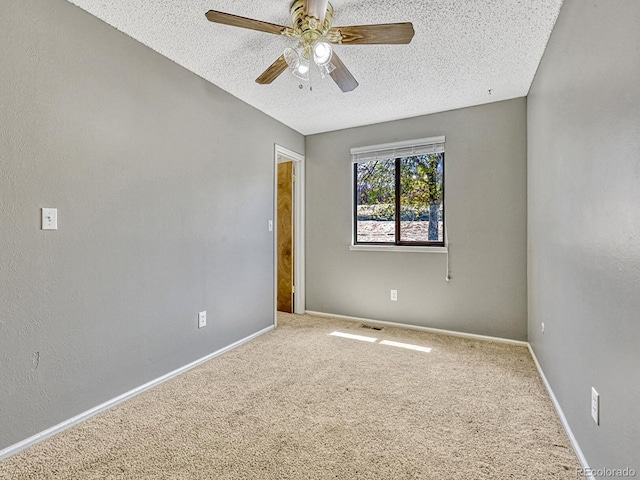 empty room featuring carpet, baseboards, a textured ceiling, and ceiling fan