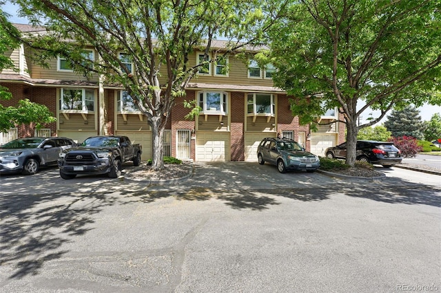 3300 W Florida Ave Unit 117, Denver, CO 80219 - view of front of property with brick siding, driveway, and a garage