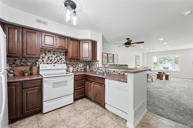 3300 W Florida Ave Unit 117, Denver, CO 80219 - kitchen featuring white appliances, light carpet, a sink, a peninsula, and decorative backsplash