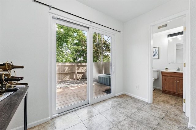 3300 W Florida Ave Unit 117, Denver, CO 80219 - doorway featuring light tile patterned flooring, a sink, and baseboards