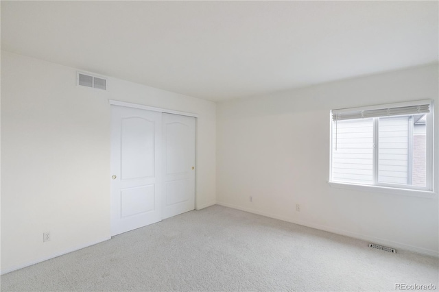 unfurnished bedroom featuring a closet and light carpet