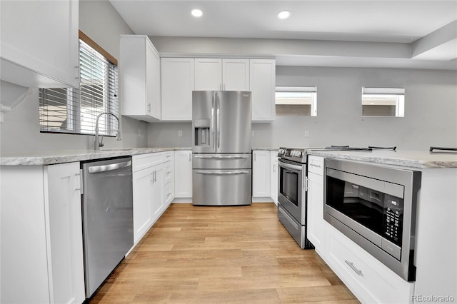 kitchen featuring a sink, recessed lighting, appliances with stainless steel finishes, white cabinets, and light wood finished floors