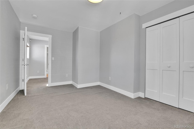 unfurnished bedroom featuring a closet, baseboards, and carpet floors